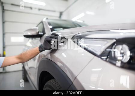 Autodetails - Der Mensch trägt eine Nano-Schutzbeschichtung auf das Auto auf. Selektiver Fokus. Stockfoto