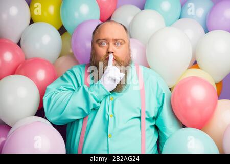 Hush sei stimmlos. Ernster Mann großes Abdomen Finger Lippen Mund fragen sagen nicht sagen sprechen sprechen privates Jubiläumsgeschenk tragen türkis rosa Hosenträger Stockfoto