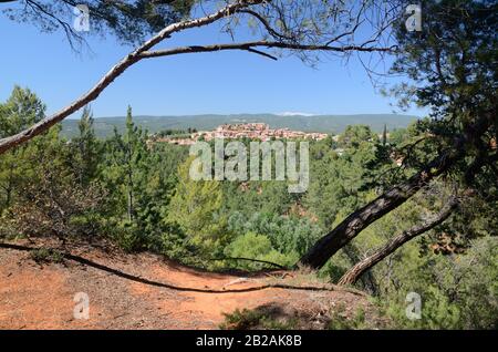 Landschaft mit Ockerfarbenen Auswüchsen und Pine Trees, Die Das Dorf Rousillon im Luberon Regional Park Vaucluse Provence France Umrahmen Stockfoto