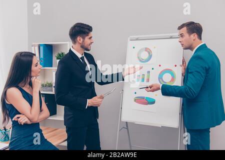 Junger Geschäftsmann, der im Büro auf die Windramen auf dem Flipboard zeigt Stockfoto