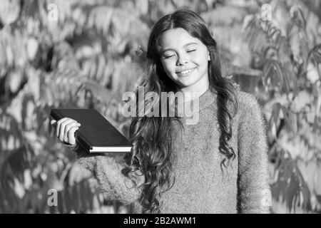 Herbst Literatur konzept. Kleines Kind lernen Sie im Herbst Park. Kid Studie mit Buch. Studiere weiter. Kleines Mädchen Buch lesen im Herbst Tag. Kleines Kind lesen Herbstlaub Hintergrund. Stockfoto