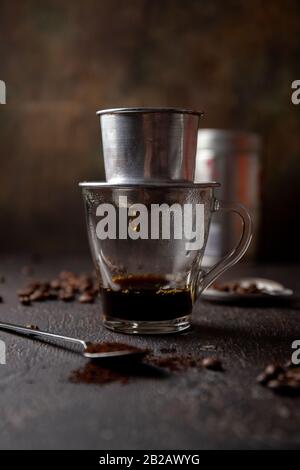 Vorbereitung der vietnamesischen Kaffee mit Aluminium cofe Filer auf dunklem Hintergrund Stockfoto