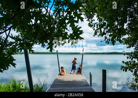 Drei Kinder auf einem Dock angeln, USA Stockfoto