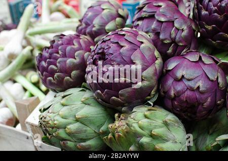 Frische reife violette Artischocken auf dem Obstmarkt Stockfoto