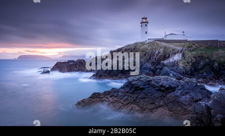 Die Dämmerung ertragst bis zum Morgengrauen, Sonnenaufgang im Fanad Head Lighthouse mit verschwommenem Wasser des Atlantiks. Wild Atlantic Way, Donegal, Irland Stockfoto