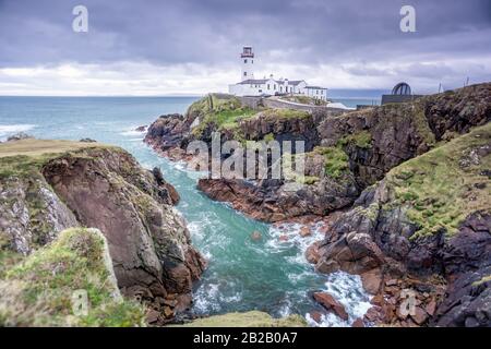 Stürmischer Himmel im Fanad Head Lighthouse auf dem Wild Atlantic Way. Schöne Halbinsel Fanad Head mit Klippen und türkisfarbenem Wasser darunter, Donegal, Irland Stockfoto