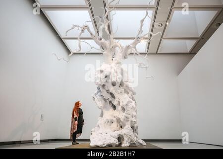 Hayward Gallery, London, Großbritannien. März 2020. Ein Assistent posiert mit Ugo Rondinons 'kaltem Mond'. Die 18 Meter hohe 1700kg-Skulptur eines aus Aluminium gegossenen und lackierten weißen Webs, die über der Galerie hoch sind. "Unter den Bäumen" in der Hayward Gallery ist eine monumentale Ausstellung, die uns wieder einmal vorstellt, wie wir über Bäume und Wälder denken und wie sie die menschliche Zivilisation geprägt haben. Mehr als 80 Werke sind ausgestellt. Es läuft vom 4. März bis zum 17. Mai. Kredit: Imageplotter/Alamy Live News Stockfoto