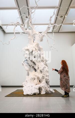 Hayward Gallery, London, Großbritannien. März 2020. Ein Assistent posiert mit Ugo Rondinons 'kaltem Mond'. Die 18 Meter hohe 1700kg-Skulptur eines aus Aluminium gegossenen und lackierten weißen Webs, die über der Galerie hoch sind. "Unter den Bäumen" in der Hayward Gallery ist eine monumentale Ausstellung, die uns wieder einmal vorstellt, wie wir über Bäume und Wälder denken und wie sie die menschliche Zivilisation geprägt haben. Mehr als 80 Werke sind ausgestellt. Es läuft vom 4. März bis zum 17. Mai. Kredit: Imageplotter/Alamy Live News Stockfoto