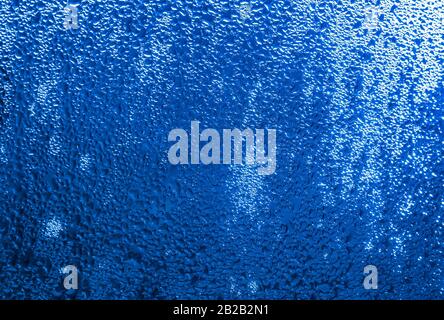 Regen an einem Fenster mit Farbanpassung für Pantone 19-4052 Classic Blue, Farbe des Jahres 2020. Pantone Farbe des Jahres 2020. Stockfoto