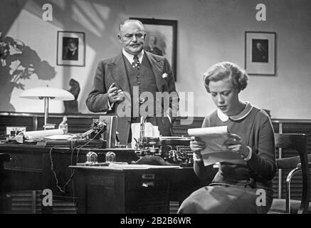 Filmszene aus "Das Erste Recht des Kindes" von Fritz Wendhausen. Der Betreuer (gespielt von Hermann Vallentin) und der Stenotypist (gespielt von Hertha Thiele) sind in einem Büro. Stockfoto