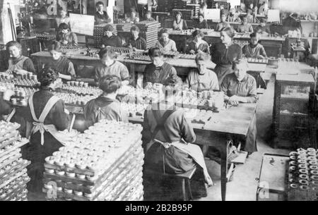 Frauen bei der Arbeit in einem Feuerwerklabor. Hier sind verschiedene Arbeitsschritte beim Beladen und Zusammenbau der Zünder notwendig. Stockfoto