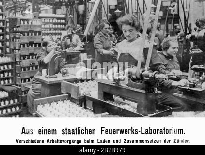 Frauen bei der Arbeit in einem Feuerwerklabor. Hier sind verschiedene Arbeitsschritte beim Beladen und Zusammenbau der Zünder notwendig. Stockfoto