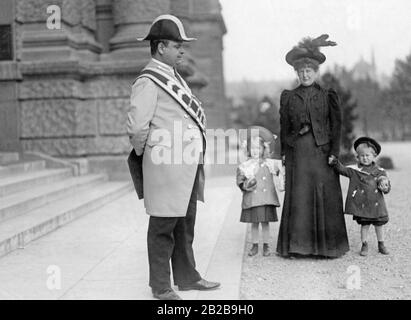 Eine Gouvernante hält ein kleines Mädchen und einen kleinen Jungen an den Händen vor dem Kaiserlich Königlichen Naturhistorischen Museum in Wien. Stockfoto