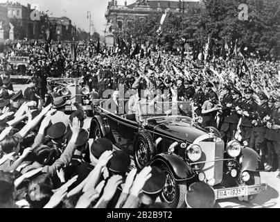 Wiener Bürger jubeln den NS-Funktionären Adolf Hitler und Franz von Papen bei ihrer Fahrt durch Wien, hier an der Ringstraße, zu. Stockfoto