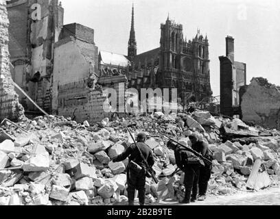 Blick auf den Dom in Amiens nach der Eroberung durch die Wehrmacht. Im Vordergrund legen Soldaten einer deutschen Kommunikationseinheit Telefonkabel. Stockfoto