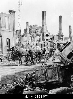 Ein deutscher Wagen zwischen zerstörten Häusern in Brunehamel. Stark retuschiert. Stockfoto