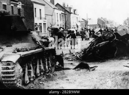 Zivilisten fahren an einem downed französischen Somua 35-Panzer vorbei und wandern durch die Straßen Avesnes. Foto: Boesig Stockfoto