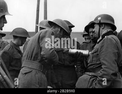 Britische Soldaten, die nach der Schlacht von Dünkirchen von Deutschen gefangen genommen wurden, werden von einem Mitglied einer Propagandakompanie (rechts) befragt. Stockfoto