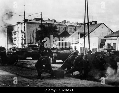 Deutsche Panzer II und eine deutsche Infanteriepistole während einer Straßenkämpfe in Warschau. Stockfoto