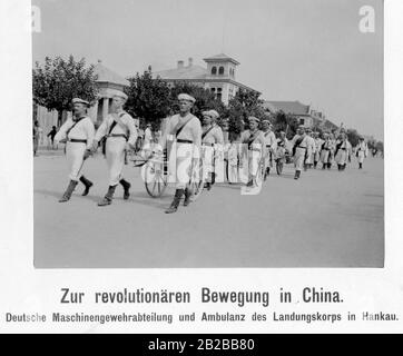 Ein deutsches Maschinengewehr-Ablösegerät und Rettungswagen des Landungskorps marschiert während der chinesischen Revolution über eine Straße in der deutschen Kolonie in Hankou in China. Stockfoto