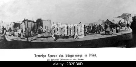 Blick auf die in der chinesischen Revolution zerstörte Stadt Hankau. Die Menschen laufen auf den Straßen herum. Die Häuser sind zerstört. Heute gehört Hankau zur Stadt Wuhan. Stockfoto