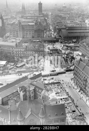 Blick von der Spitze des Turms der St.-Georgs-Kirche auf den Alexanderplatz. Die links im Vordergrund befindlichen Gebäudekomplexe werden abgerissen. Im Hintergrund die überlastete Koenigsstraße und der Turm des Berliner Rathauses. Links im Hintergrund die Türme der Nikolauskirche (deutsch: Nikolaikirche). Stockfoto