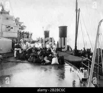 Auf hoher See versorgt das Schlachtschiff "Kaiser Wilhelm der grosse" ein Torpedoboot mit Kohle, das für den Einsatz benötigt wird. Stockfoto