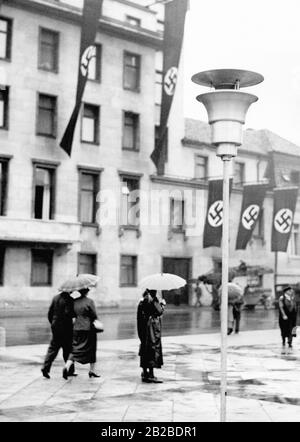 Hakenkreuzfahnen werden bei der Erweiterung der neuen Berliner Staatskanzlei gehisst. Passanten gehen am Gebäude vorbei. Stockfoto