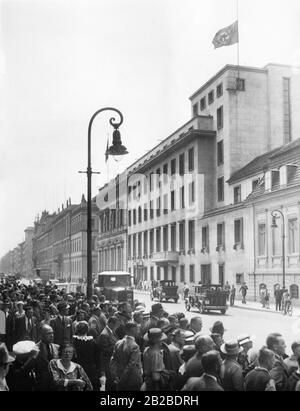 Die Bürger versammeln sich vor der Reichskanzlei zur Gedenkfeier für die gefallenen Soldaten des vor kurzem abgeschossenen Kriegsschiffs "Deutschland". Daher steht die Hakenkreuzfahne auf dem Dach der Staatskanzlei auf halbmast. Stockfoto