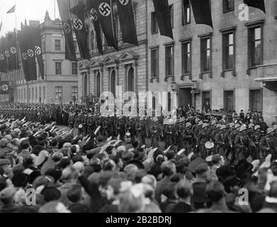 Das Wiener Infanterie-Bataillon wird in Berlin feierlich empfangen. Passanten durchmachen den Straßenrand und machen den Nazi-Salut. Hakenkreuzfahnen werden an den Gebäuden gehisst. Das Bataillon passiert die neue Reichskanzlei. Stockfoto