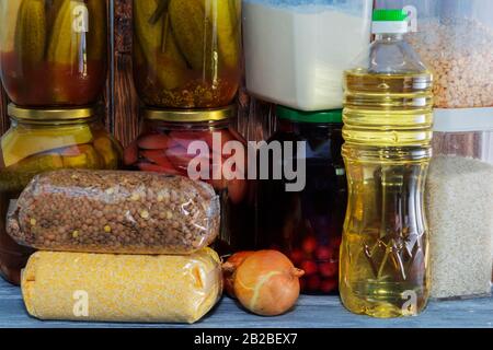 Viele Glasgefäße mit Konserven und Getreide auf einem Holzregal. Stockfoto