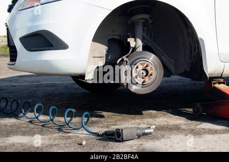 Auto ohne Rad und mit Hydraulik anheben, warten auf Reifenwechsel. Stockfoto