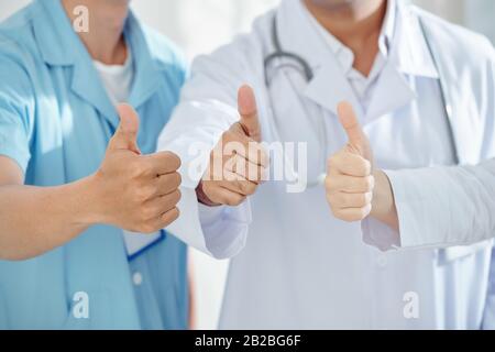 Nahaufnahme von Ärzten und Chirurgen, die nach der Genesung der Patienten die Daumen nach oben zeigen Stockfoto