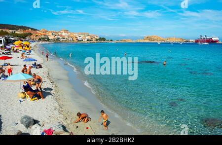 Ile-ROUSSE, FRANKREICH - 22. SEPTEMBER 2018: Menschen am Hauptstrand von Ile-Rousse, Korsika, Frankreich, und der Insel Ile de la Pietra sowie ein Schiff an der fe Stockfoto