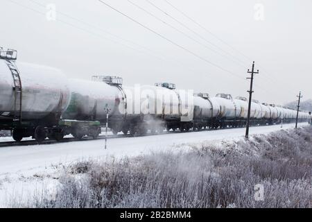 Zug mit Öltanks in Bewegung. Transport von Treibstoff auf der Eisenbahn. Stockfoto