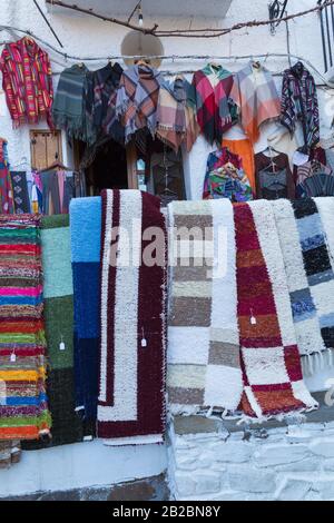 Traditionelle Teppiche, die im Februar im Laden in Pampaneira, Andalucia, Spanien, hängen - örtlich angefertigtes Kunsthandwerk Stockfoto