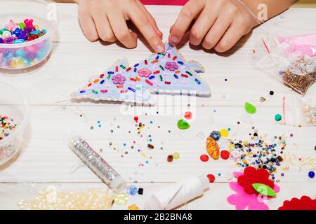 Handgemachtes Weihnachtsspielzeug. Schritt für Schritt. Prozess der handgefertigten weichen Spielzeug Nähen mit Filz und Nadel für Weihnachtsbaum Dekoration. Stockfoto