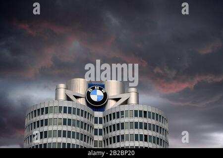 Coronavirus (Covid-19) bei BMW in München. Ein BMW-Mitarbeiter in München hat positiv auf das Corona-Virus getestet. Eine BMW-Sprecherin sagte am Montag, er sei nicht unterwegs und habe im Forschungs- und Entwicklungszentrum (FIZ) gearbeitet. Archivfoto; FOTOMONTAGE: Dunkle Prognosen im BMW-Sparprogramm des Automobilherstellers BMW kürzen tausende hochqualifizierte Arbeitsstunden und Gehälter. Archivfoto; Grenzmotiv mit BMW-Logo in der BMW-Konzernzentrale, Hochhaus, Doppelkegel, Firmensitz, BMW-Museum, Gebäude.zentral, Außenaufnahme, Gebäude, Hochhaus, Autohersteller, Auto, Autos, au Stockfoto