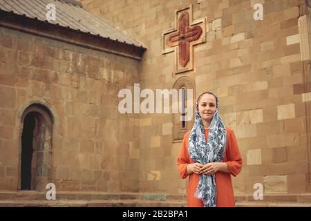 Orthodoxe Frau vor dem Hintergrund einer altchristlichen Kirche Stockfoto