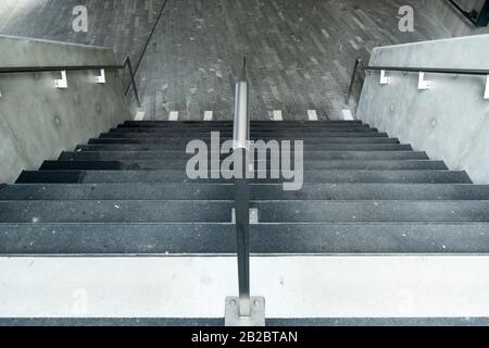 Weiße Markierungen, die auf blinde und sehbehinderte Menschen hinweisen, sind ein Landewechsel auf der Treppe eines Leman-Express-Bahnhofs in Genf, Schweiz Stockfoto