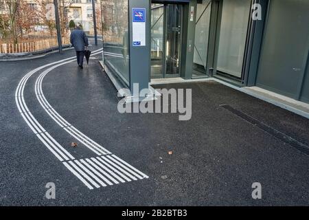 Blindes Fußgängergehen und erkennen von Markierungen auf der taktilen Pflasterung für Blinde und Sehbehinderte in einer Leman Express Station in Genf, Schweiz Stockfoto