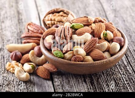 Muttern in einer Holzplatte vermischen Stockfoto