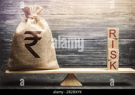 Geldbeutel und Holzklötze mit dem Wort Risiko auf der Waage. Management und Bewertung von Geschäftsrisiken. Strategische, finanzielle und operative Risiken. Ins Stockfoto