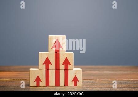 Holzblöcke mit roten Pfeilen. Der Prozess der erfolgreichen Entwicklung von Wirtschaft und Wirtschaft. Produktivität und Leistungssteigerung. Planung, Planung Stockfoto