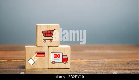 Holzblöcke mit Online-Einkaufssymbolen. Warenkorb, Zahlungskarte, Lieferwagen. Verkäufer über das Internet. E-Commerce- und Lieferservice Stockfoto