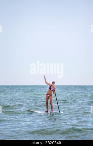 Rentner, die das Leben genießen und lernen, wie sie auf ihrem SUP-Brett in Florida aufstehen. Stockfoto