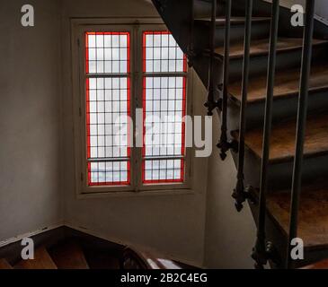 Treppenhaus in einem alten Apartmentgebäude in Paris. Gemeinsames Waschbecken und antike Buntglasfenster. Abgebrochener Zustand. Frankreich Stockfoto