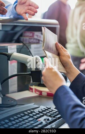 Nahaufnahme des Passagier-Servicemitarbeiters, der den Reisepass eines älteren Mannes im Flughafen ansieht Stockfoto