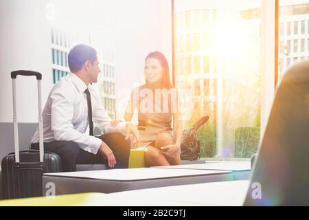 Geschäftspaar spricht während der Sitzung und des Wartens im Empfangsbereich des Hotels Stockfoto