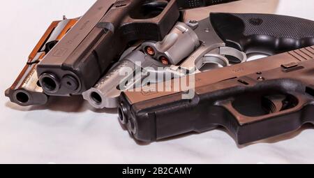 Vier Handfeuerwaffen, zwei Gewehre, Kaliber 9 mm und 40 und zwei Revolver, ein Taurus 38 Special und ein Charter Arm 357 magnum auf weißem Grund Stockfoto